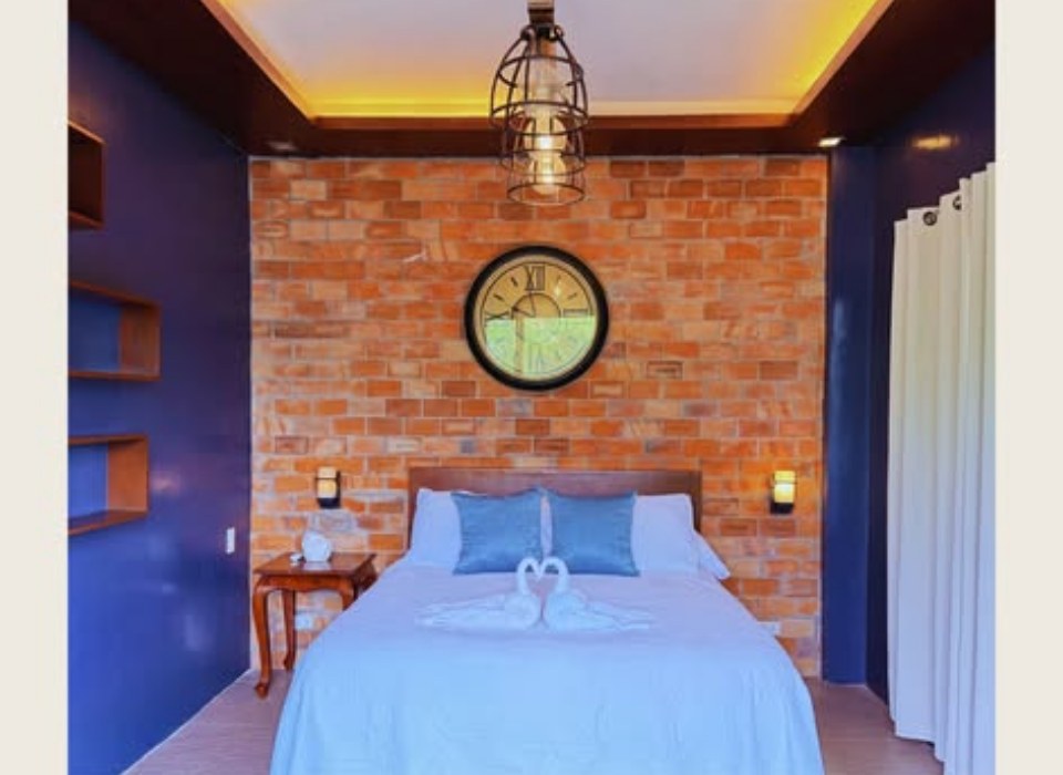 Bedroom with an exposed brick wall and a wall clock