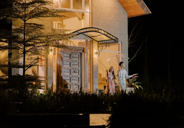 The Guest House entrance lit warm against the dark, guests at the door